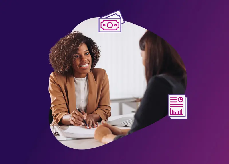 Women in suits sitting at a desk and talking