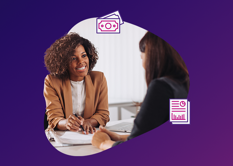 Finance professionals at a desk smiling over paperwork