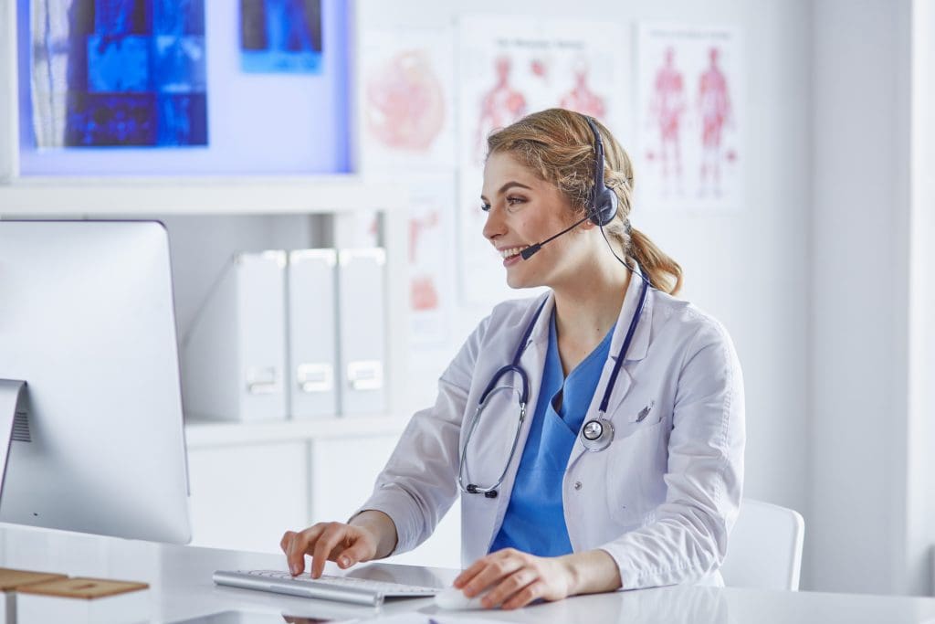 Portrait of a happy smiling young doctor in headset in office.